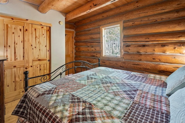 633 French Pass Cir, Jefferson, CO 80456 - bedroom featuring rustic walls, a wooden ceiling with exposed beams, and wood finished floors