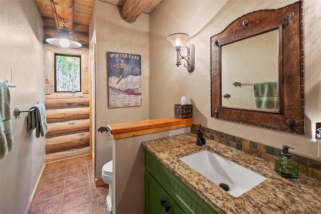 633 French Pass Cir, Jefferson, CO 80456 - bathroom featuring a wooden ceiling with exposed beams, vanity, rustic walls, and tile patterned flooring