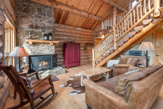 633 French Pass Cir, Jefferson, CO 80456 - living room featuring a wood ceiling with exposed beams, rustic walls, hardwood / wood-style flooring, stairway, and a stone fireplace