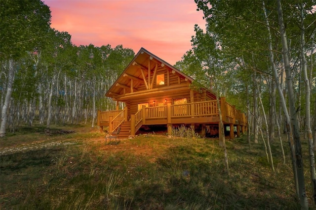 633 French Pass Cir, Jefferson, CO 80456 - back of house at dusk with log exterior and a wooden deck