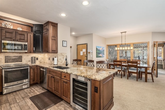 1203 W Keystone Rd Unit 2709, Keystone, CO 80435 - kitchen with beverage cooler, stainless steel appliances, a sink, light stone countertops, and a peninsula