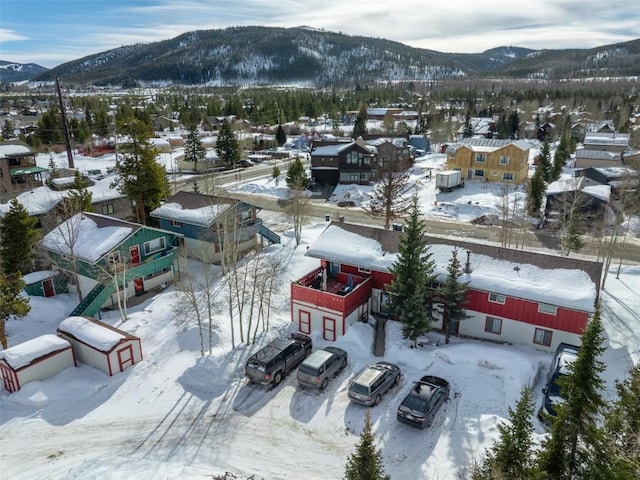 snowy aerial view featuring a residential view and a mountain view