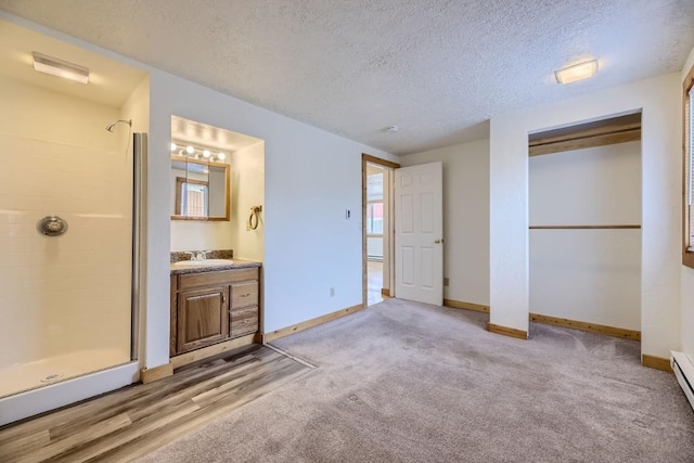 unfurnished bedroom with a textured ceiling, baseboards, connected bathroom, and a sink