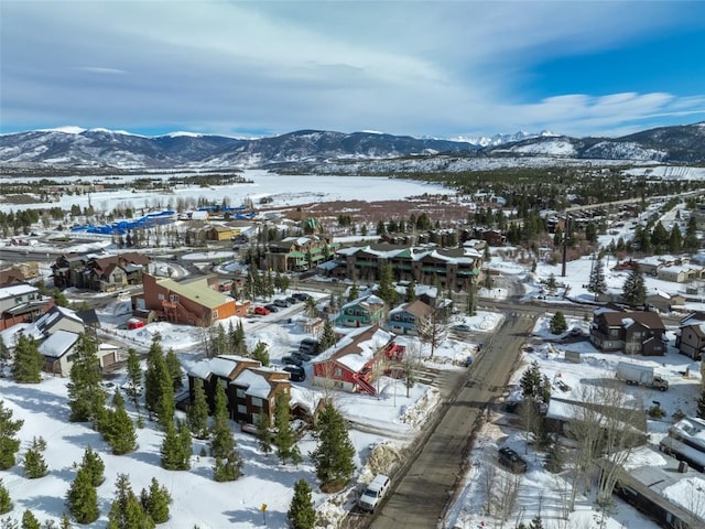snowy aerial view with a mountain view and a residential view