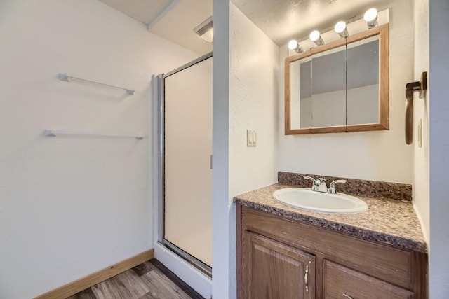 full bath with wood finished floors, vanity, and a shower stall