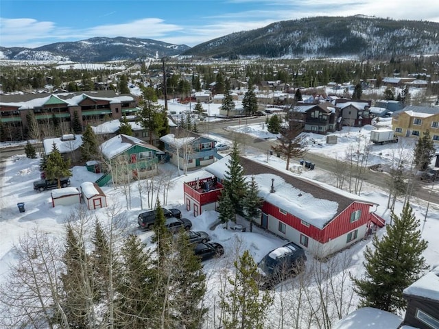 snowy aerial view featuring a mountain view and a residential view