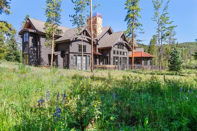 228 Cottonwood Cir, Breckenridge, CO 80424 - rear view of property with a chimney, roof with shingles, and a deck