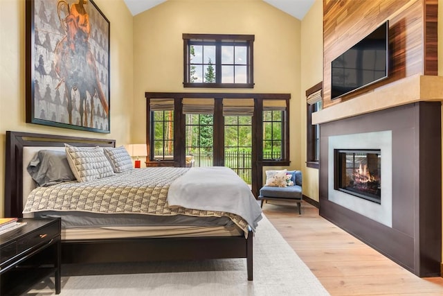 228 Cottonwood Cir, Breckenridge, CO 80424 - bedroom featuring wood finished floors, a glass covered fireplace, and high vaulted ceiling