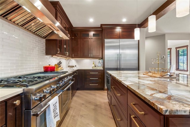 228 Cottonwood Cir, Breckenridge, CO 80424 - kitchen featuring premium appliances, wall chimney exhaust hood, light wood-type flooring, glass insert cabinets, and decorative backsplash