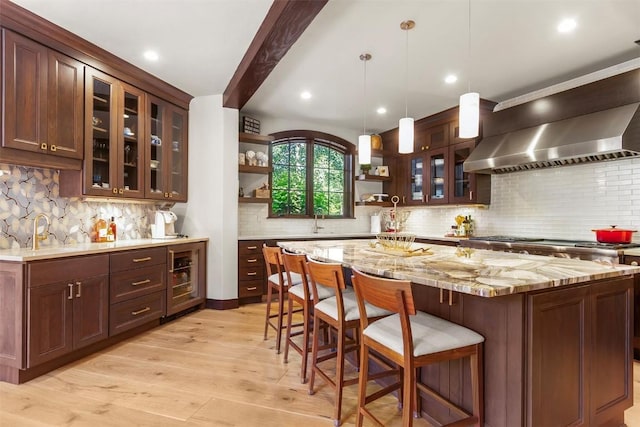 228 Cottonwood Cir, Breckenridge, CO 80424 - kitchen with open shelves, backsplash, light wood-type flooring, a kitchen bar, and beam ceiling
