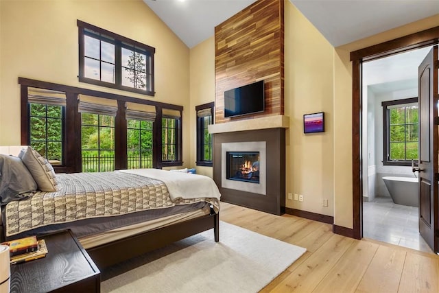 228 Cottonwood Cir, Breckenridge, CO 80424 - bedroom featuring light wood-type flooring, a fireplace, high vaulted ceiling, and ensuite bath