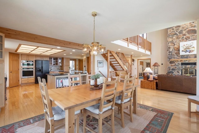 440 Gcr 466, Grand Lake, CO 80447 - dining space featuring light wood-style floors, a chandelier, stairway, recessed lighting, and a stone fireplace