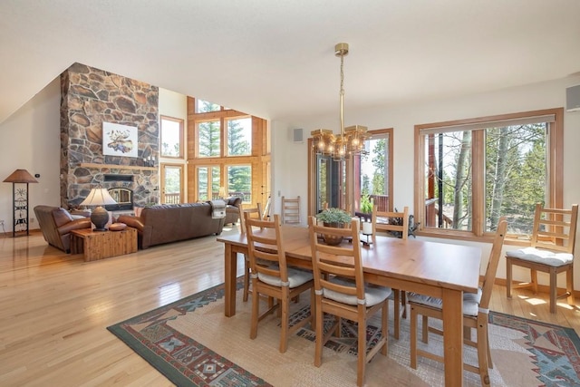 440 Gcr 466, Grand Lake, CO 80447 - dining room with light wood-style flooring, a chandelier, a fireplace, and lofted ceiling