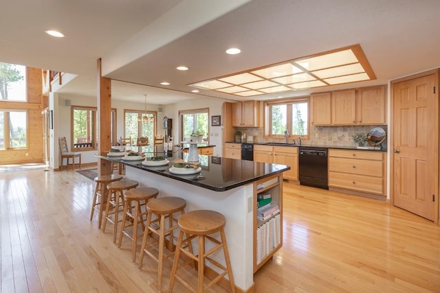 440 Gcr 466, Grand Lake, CO 80447 - kitchen with black dishwasher, light brown cabinets, a sink, dark countertops, and a breakfast bar area
