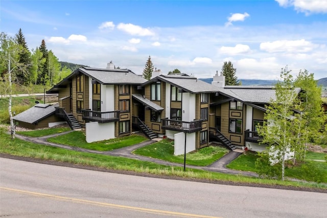 2515 Apres Ski Way Unit 5, Steamboat Springs, CO 80487 - view of front of home with stairs, a chimney, roof with shingles, and a front yard