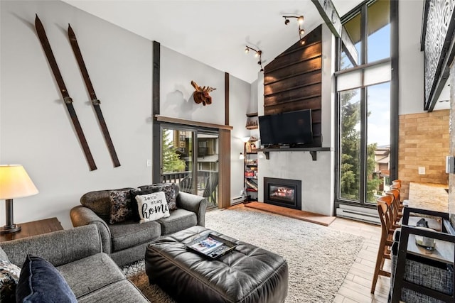 2515 Apres Ski Way Unit 5, Steamboat Springs, CO 80487 - living area with a glass covered fireplace, track lighting, plenty of natural light, high vaulted ceiling, and wood finished floors