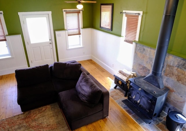 436 Clifton Ave, Yampa, CO 80483 - living area with wood finished floors, wainscoting, a wood stove, and ceiling fan