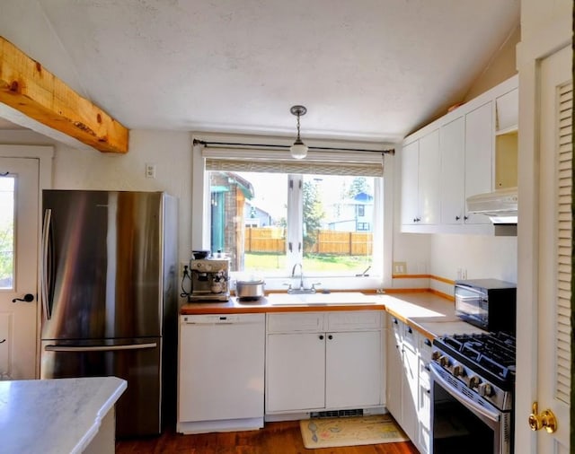436 Clifton Ave, Yampa, CO 80483 - kitchen featuring appliances with stainless steel finishes, a sink, under cabinet range hood, white cabinets, and lofted ceiling