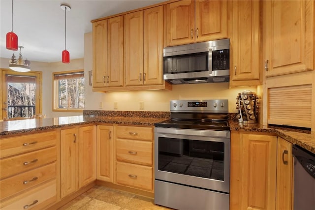 kitchen featuring a peninsula, dark stone countertops, light brown cabinets, appliances with stainless steel finishes, and hanging light fixtures