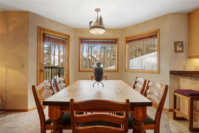 dining space with light carpet and baseboards