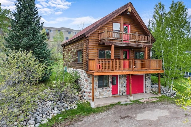 625 Amethyst Dr, Steamboat Springs, CO 80487 - view of front of house with stone siding, log exterior, dirt driveway, and a balcony