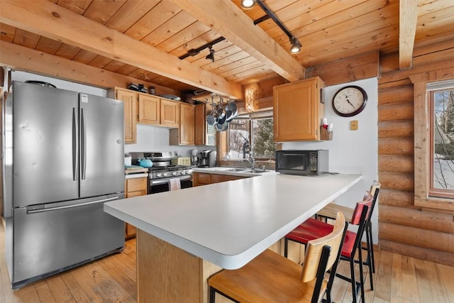 625 Amethyst Dr, Steamboat Springs, CO 80487 - kitchen with appliances with stainless steel finishes, wood ceiling with exposed beams, log walls, track lighting, and light wood-style flooring