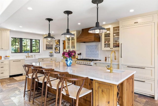 192 Nova Dr, Pine, CO 80470 - kitchen featuring custom range hood, glass insert cabinets, recessed lighting, a kitchen island, and a kitchen bar