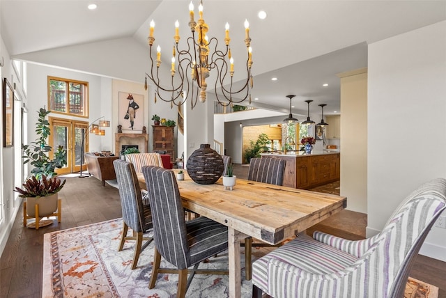 192 Nova Dr, Pine, CO 80470 - dining room featuring dark wood-style flooring, a chandelier, vaulted ceiling, recessed lighting, and a fireplace