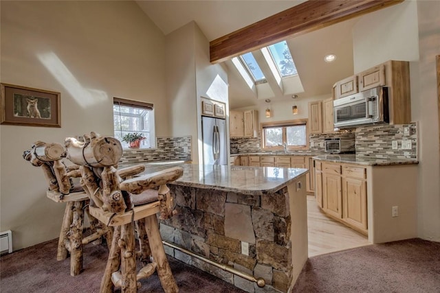 61 Pine Cir, Breckenridge, CO 80424 - kitchen featuring appliances with stainless steel finishes, a skylight, light carpet, light stone counters, and tasteful backsplash