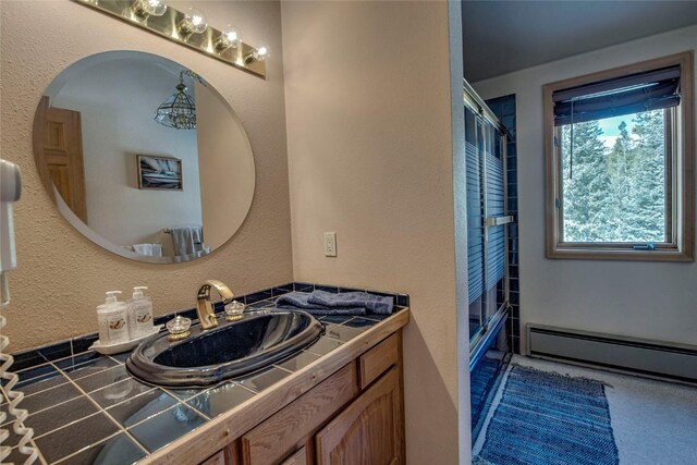 61 Pine Cir, Breckenridge, CO 80424 - bathroom with a textured wall, vanity, a shower with shower door, and a baseboard radiator