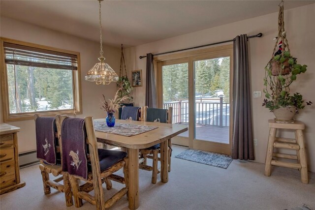 61 Pine Cir, Breckenridge, CO 80424 - dining space featuring a baseboard heating unit, a notable chandelier, light colored carpet, and a healthy amount of sunlight