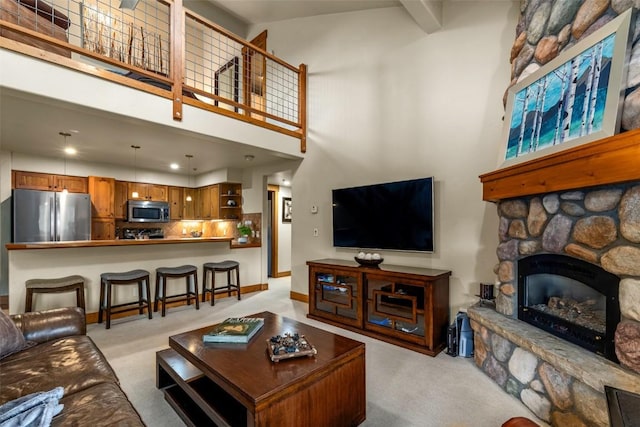 435 Ore House Plz Unit 301, Steamboat Springs, CO 80487 - living area with a high ceiling, light carpet, a stone fireplace, and recessed lighting