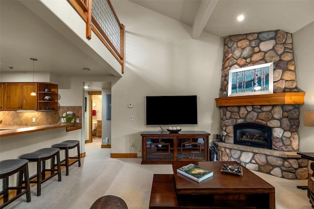 435 Ore House Plz Unit 301, Steamboat Springs, CO 80487 - living area with a stone fireplace, beamed ceiling, light carpet, and a high ceiling