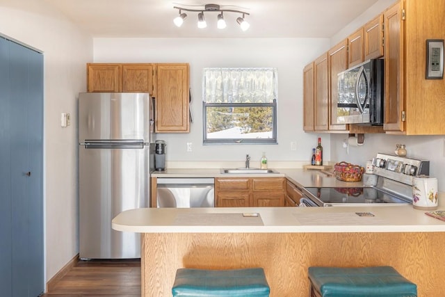 122 Gcr 442 Unit 2B, Grand Lake, CO 80447 - kitchen featuring a peninsula, a sink, light countertops, dark wood-type flooring, and appliances with stainless steel finishes
