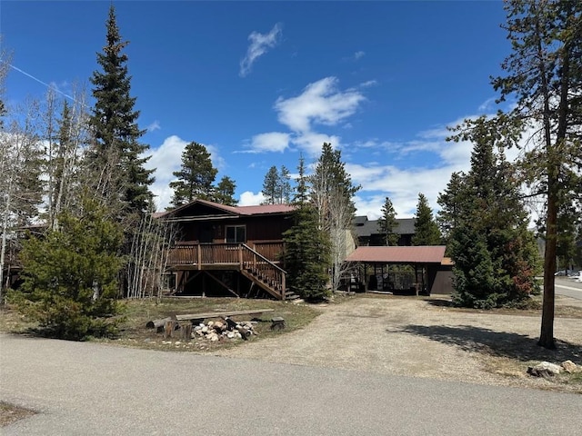 view of front facade with stairs and dirt driveway