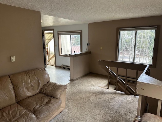 living room with light colored carpet, a textured ceiling, and baseboard heating