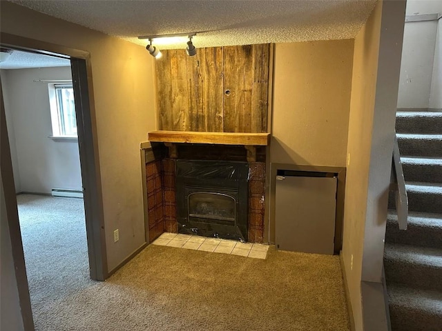 unfurnished living room with carpet floors, track lighting, stairs, a textured ceiling, and a baseboard radiator