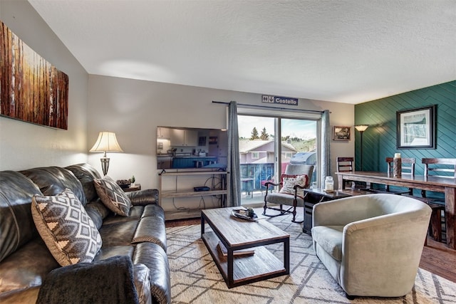 1153 Straight Creek Dr Unit 204, Dillon, CO 80435 - living area featuring wood finished floors, an accent wall, a textured ceiling, and wooden walls