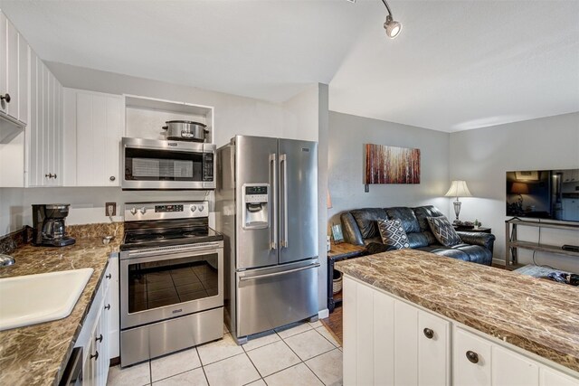 1153 Straight Creek Dr Unit 204, Dillon, CO 80435 - kitchen with stainless steel appliances, open floor plan, a sink, light tile patterned floors, and white cabinetry