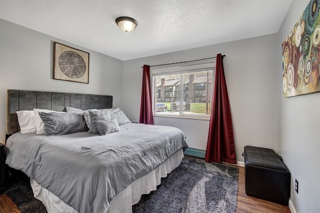 1153 Straight Creek Dr Unit 204, Dillon, CO 80435 - bedroom with wood finished floors, baseboard heating, and baseboards