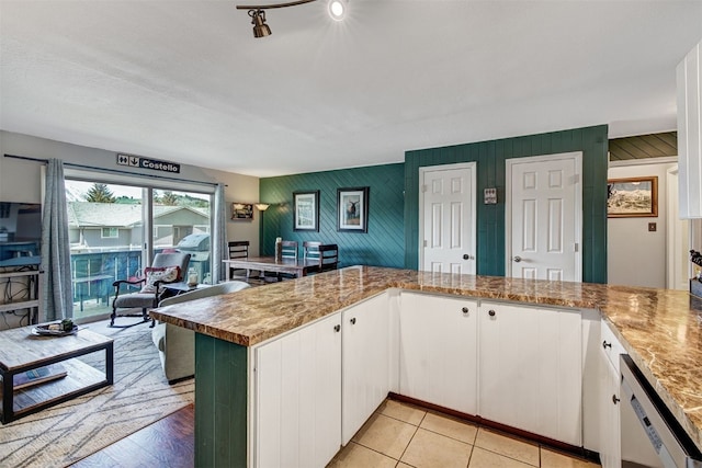 1153 Straight Creek Dr Unit 204, Dillon, CO 80435 - kitchen with dishwasher, white cabinetry, a peninsula, and wooden walls