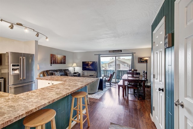 1153 Straight Creek Dr Unit 204, Dillon, CO 80435 - kitchen with high end refrigerator, dark wood finished floors, a breakfast bar area, light countertops, and open floor plan