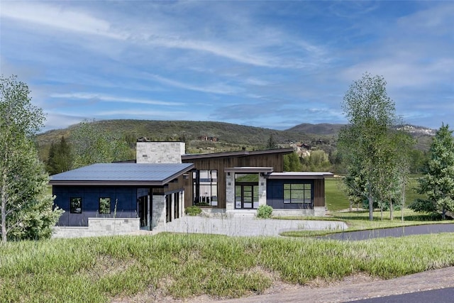 971 Steamboat Blvd, Steamboat Springs, CO 80487 - view of front of home featuring a mountain view, stone siding, and a chimney
