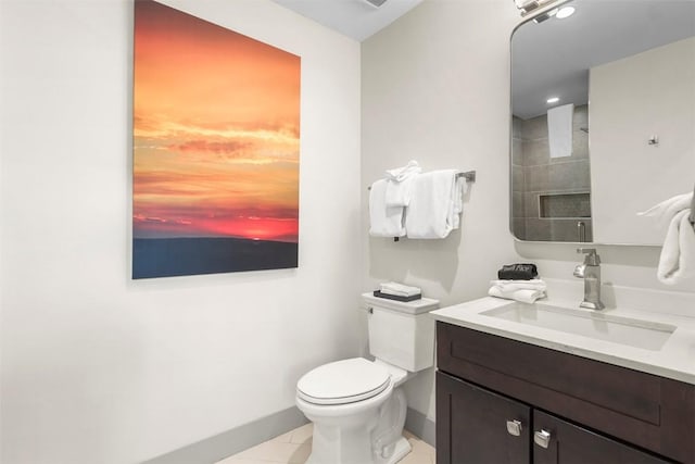 bathroom featuring baseboards, tile patterned floors, toilet, and vanity