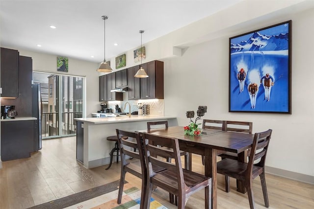 dining room featuring recessed lighting, baseboards, and light wood finished floors