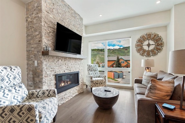 living area featuring recessed lighting, wood finished floors, and a fireplace