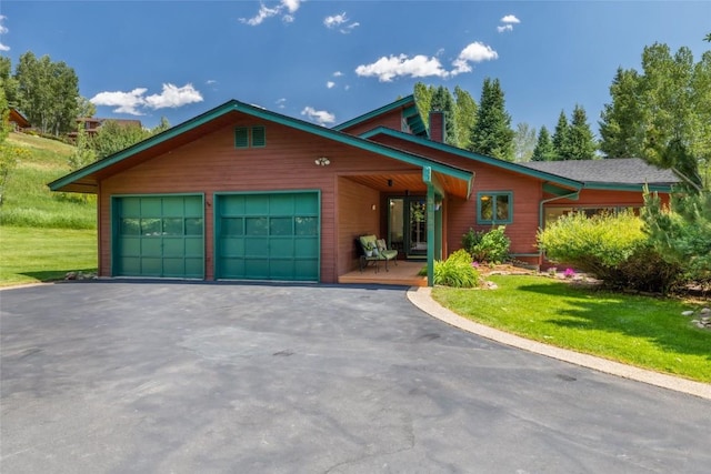 31650 Mt Werner Rd, Steamboat Springs, CO 80487 - view of front of home with asphalt driveway, a garage, and a front yard