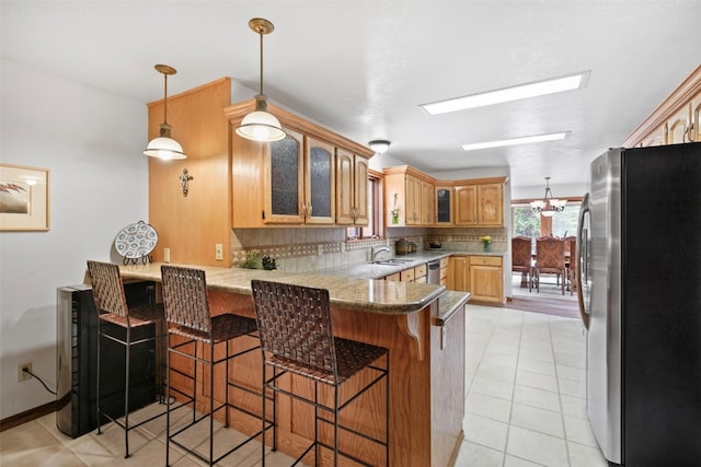 112 N Pine St, Breckenridge, CO 80424 - kitchen featuring stainless steel appliances, a peninsula, decorative backsplash, glass insert cabinets, and a breakfast bar