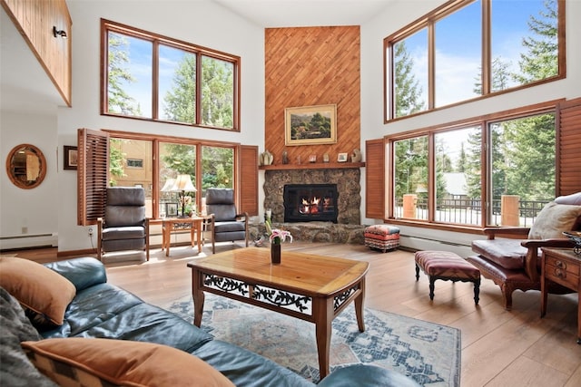 112 N Pine St, Breckenridge, CO 80424 - living room with a towering ceiling, a baseboard radiator, wood finished floors, and a stone fireplace