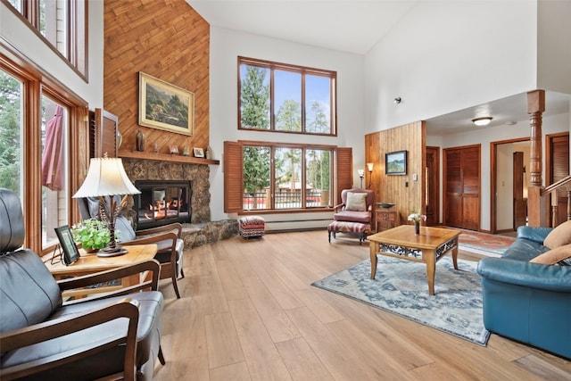 112 N Pine St, Breckenridge, CO 80424 - living area featuring high vaulted ceiling, plenty of natural light, a baseboard radiator, a fireplace, and wood walls